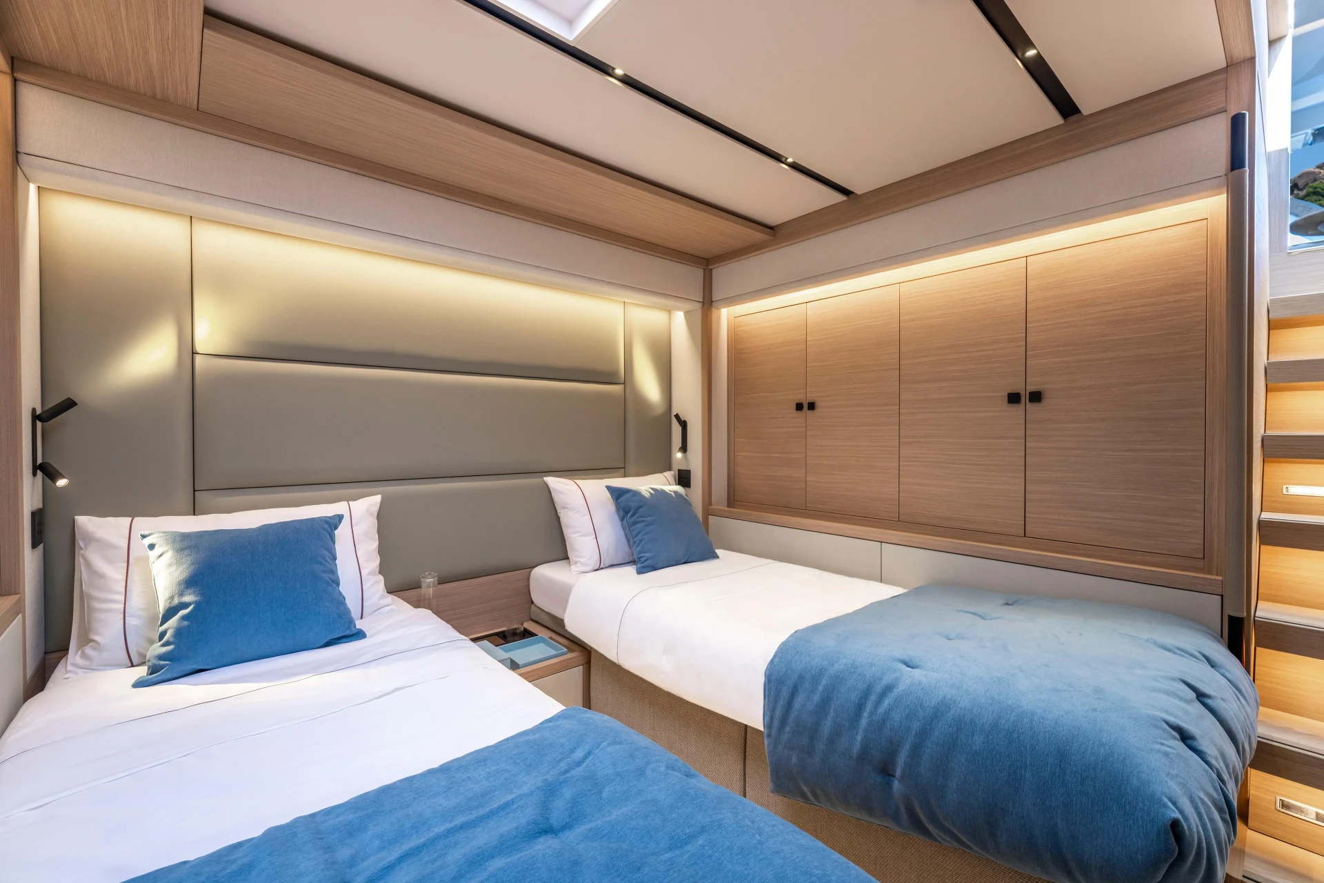 Guest cabin of the Lagoon Eighty2 with twin beds, warm wood panelling and soft natural light