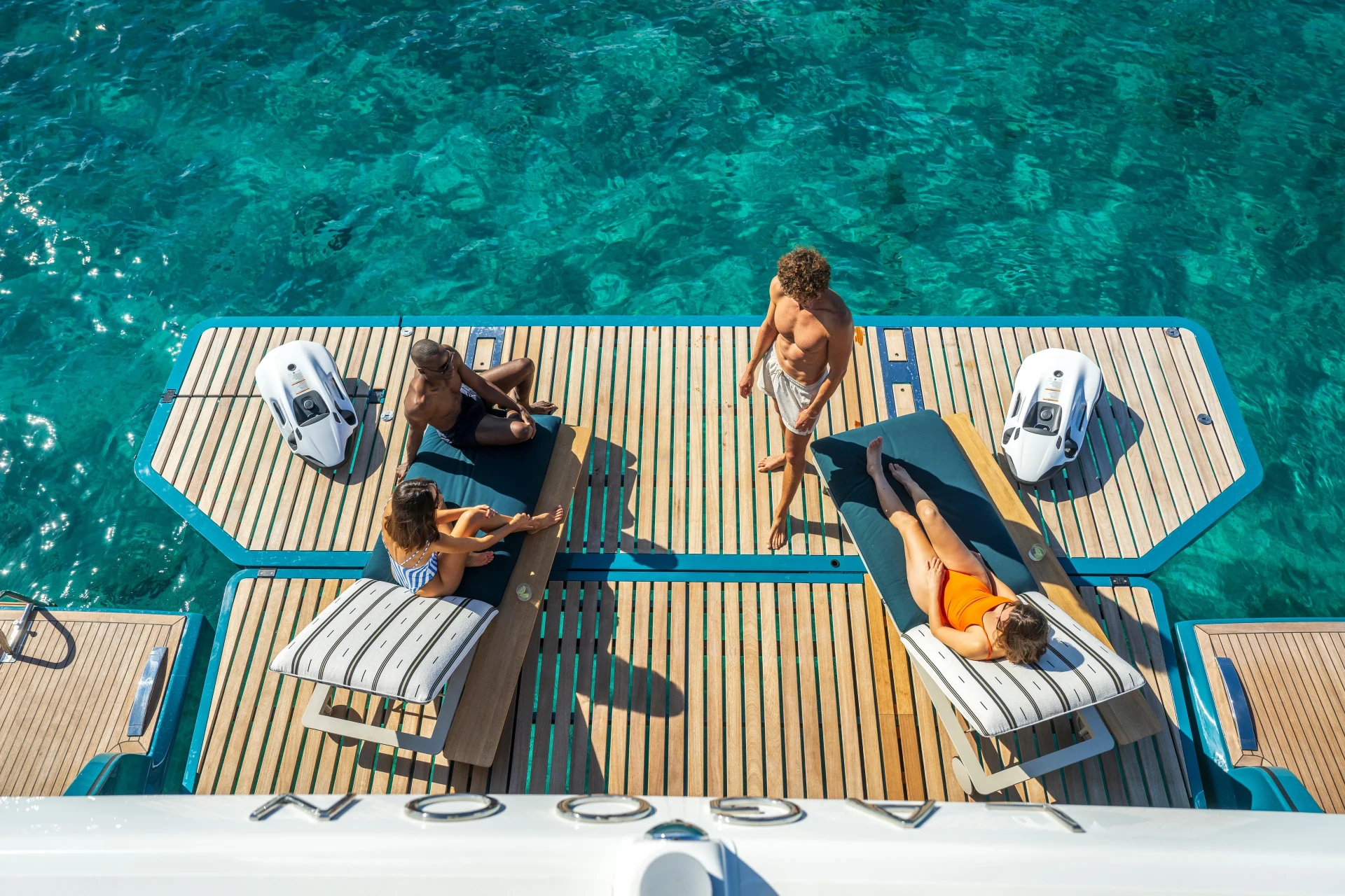 Aerial view of guests relaxing on the Lagoon Eighty2 swim platform above turquoise water